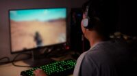 back-view-young-gamer-playing-video-games-home_12892-23
