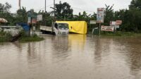 Truk melalui jalanan yang tergenang setelah hujan deras di Kota Batam,
